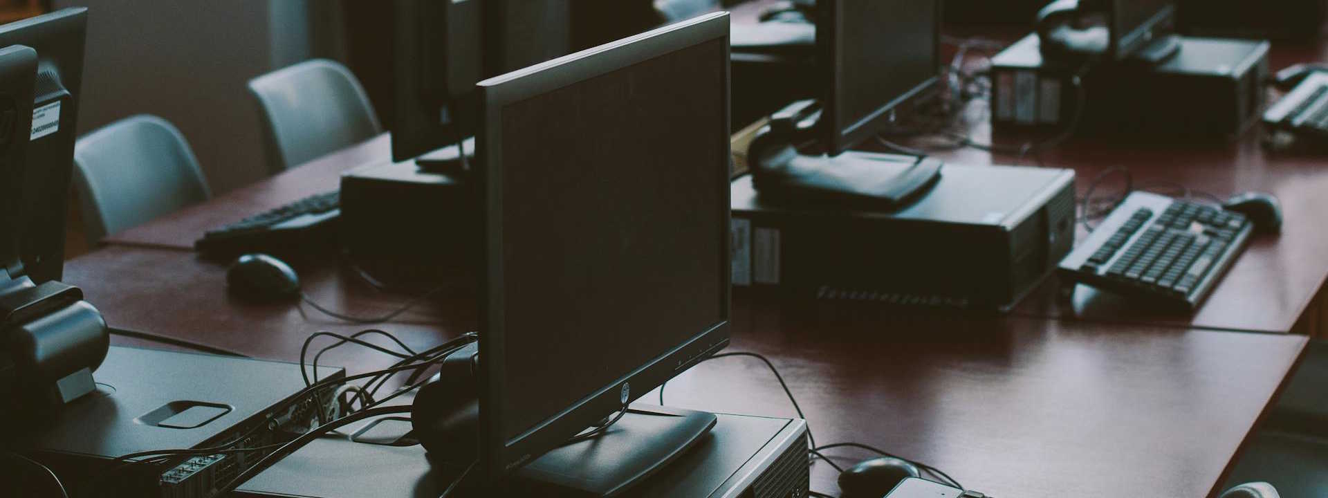 Rows of Computers huddled on a table.